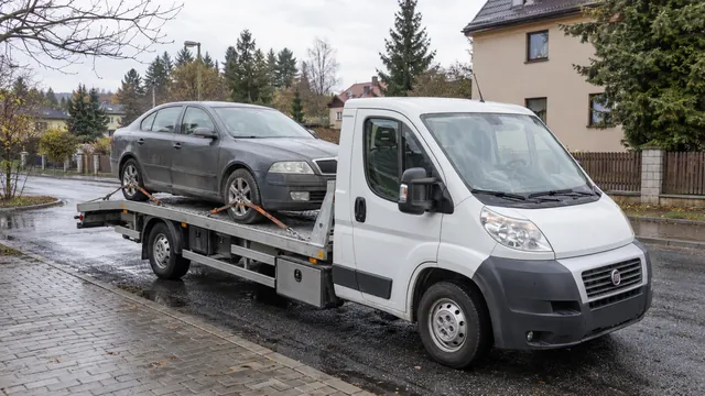 Bílý odtahový vůz s upevněným vozidlem Škoda na hliníkové plošině